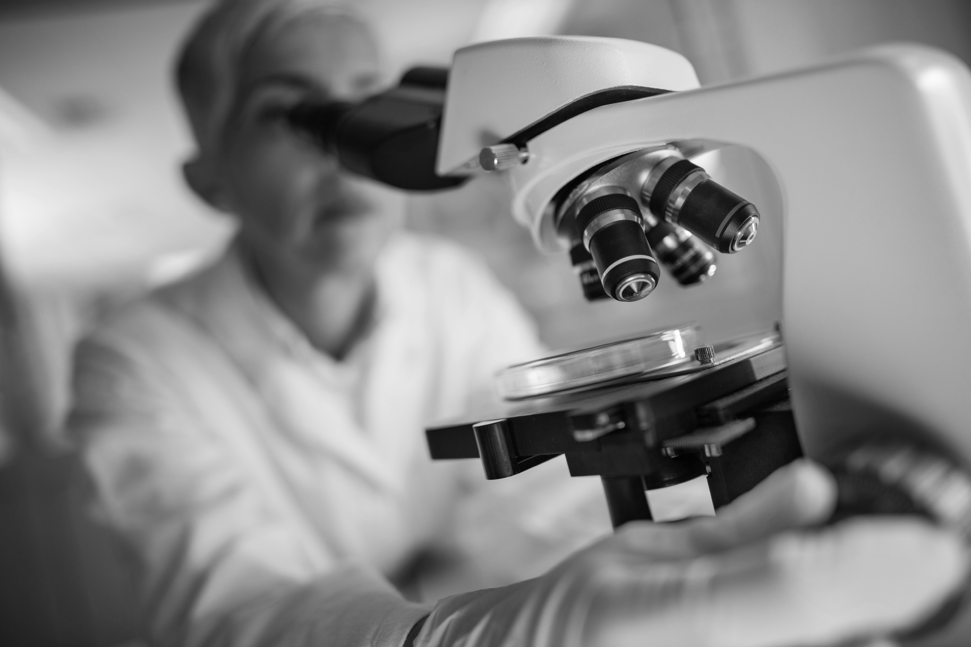 Lab technician looking into a microscope